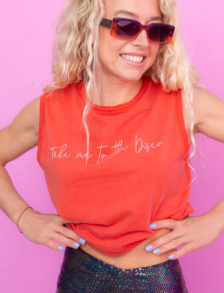 A woman wearing an orange tank top with writing across the front