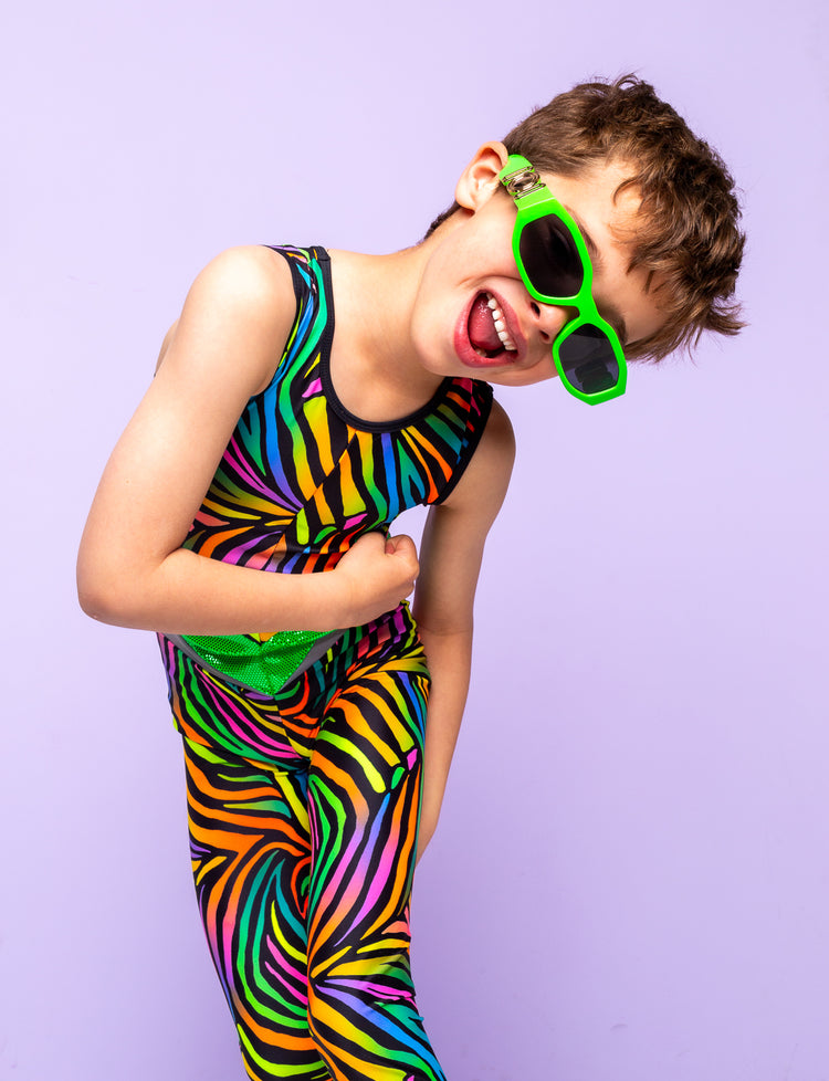 Boy modelling a multi coloured zebra print lycra catsuit and lime green sunglasses.