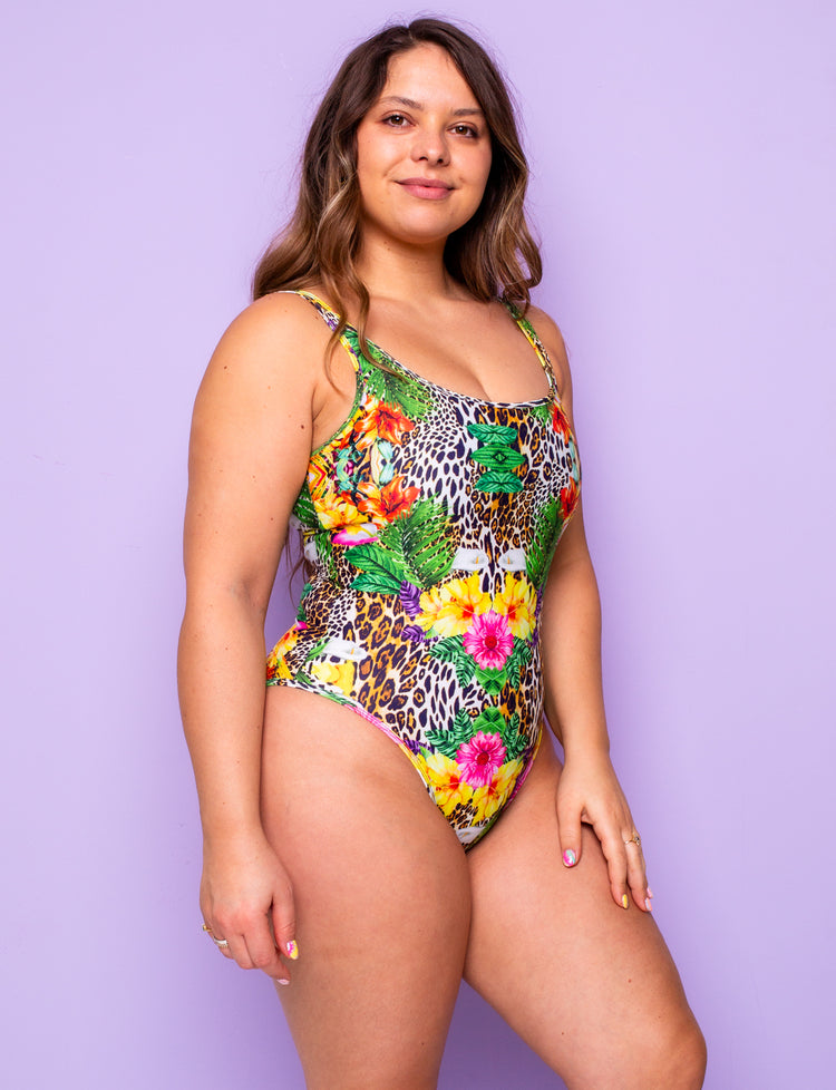 Side view of a woman wearing a tropical leopard print lycra bodysuit.