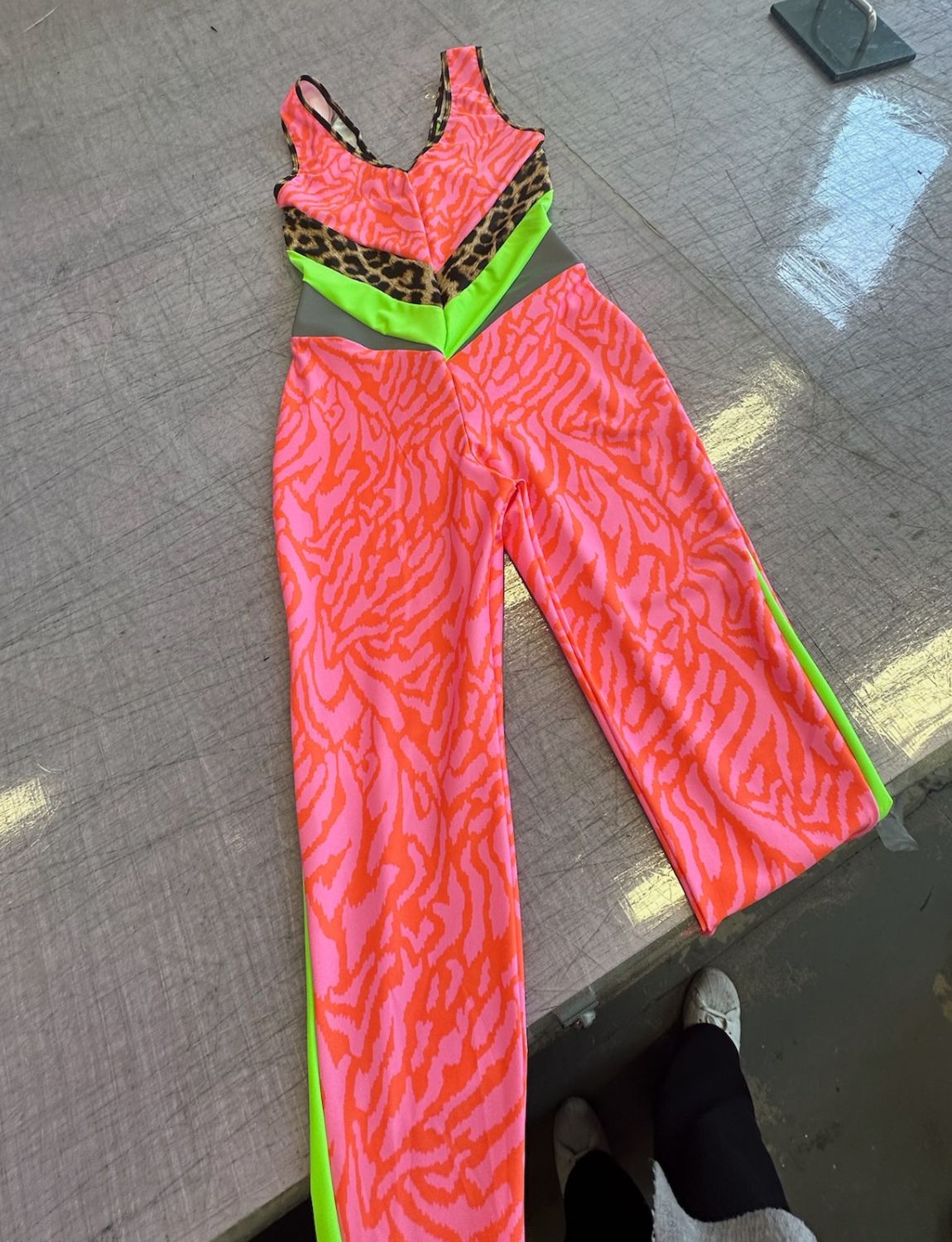 Bright pink lycra zebra print catsuit with neon green panels.