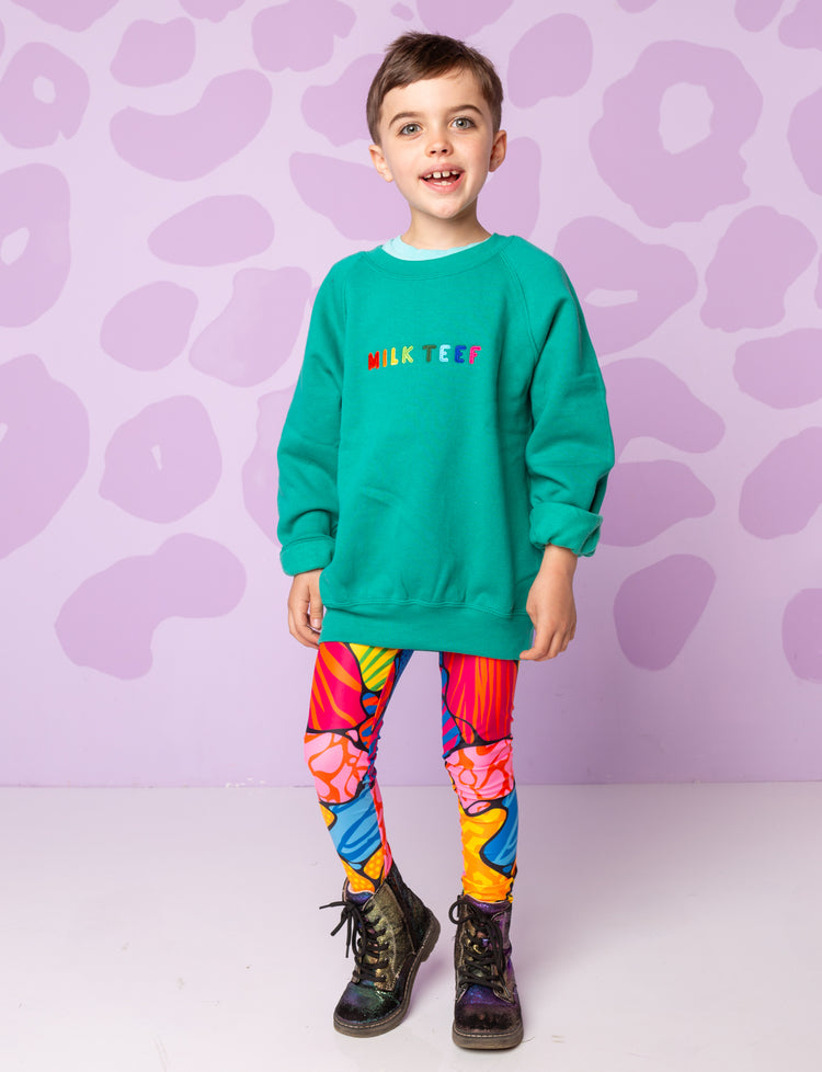 Boy wearing Burnt Soul Holy Moly leggings with a turquoise sweatshirt