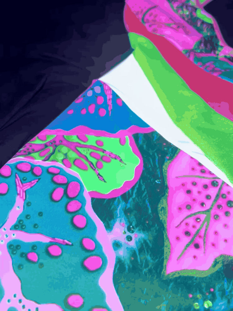 Flashing lights showing the reflective panels and uv patterns on a green and pink patterned catsuit