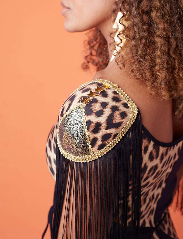 A model wearing joan shoulder pads that have gold binding and black fringing